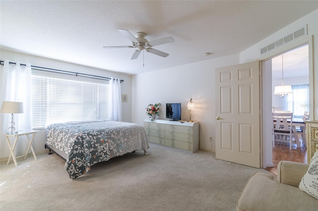 carpeted bedroom with a textured ceiling and ceiling fan