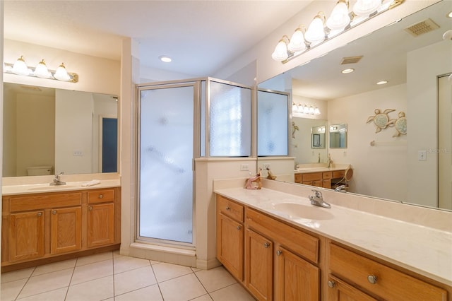 bathroom with toilet, vanity, tile patterned floors, and walk in shower