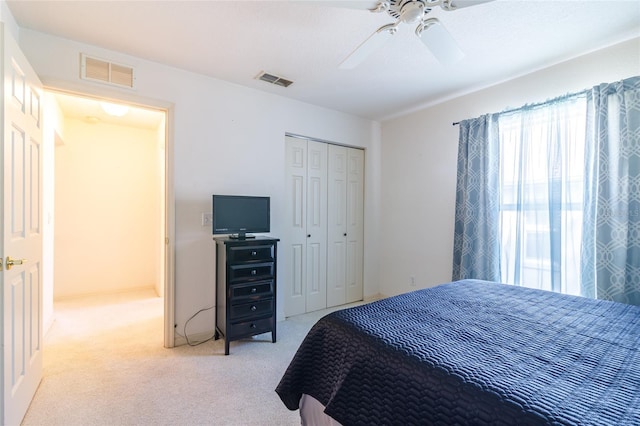 carpeted bedroom featuring ceiling fan and a closet