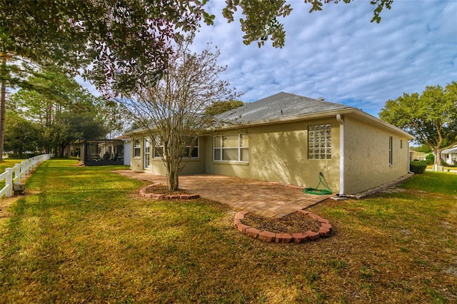 rear view of house featuring a lawn and a patio area