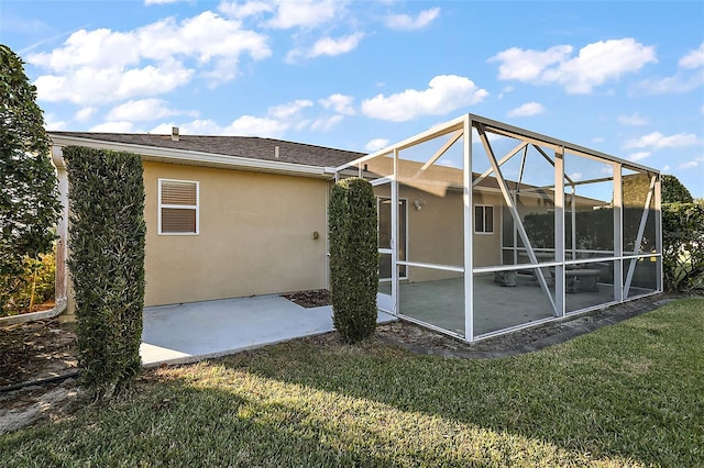 rear view of house featuring a patio, a lanai, and a lawn