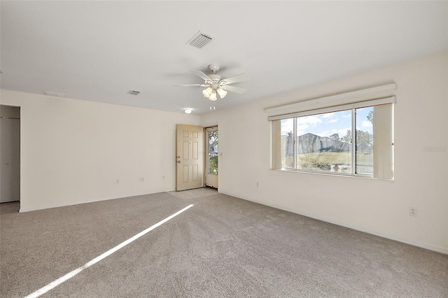 spare room with ceiling fan and light colored carpet