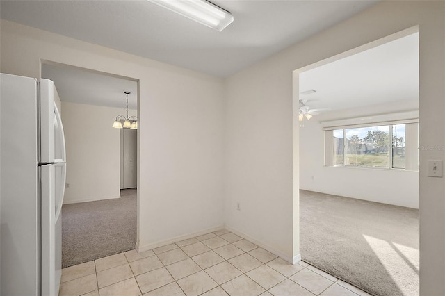 spare room with light colored carpet and ceiling fan with notable chandelier