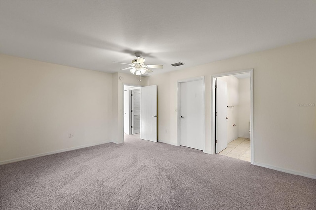 unfurnished bedroom featuring ensuite bathroom, ceiling fan, and light colored carpet