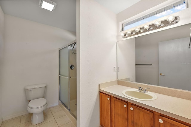 bathroom featuring tile patterned floors, vanity, a shower with shower door, and toilet