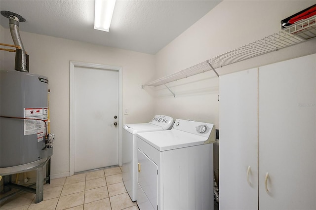 laundry room featuring light tile patterned flooring, washing machine and dryer, a textured ceiling, and water heater