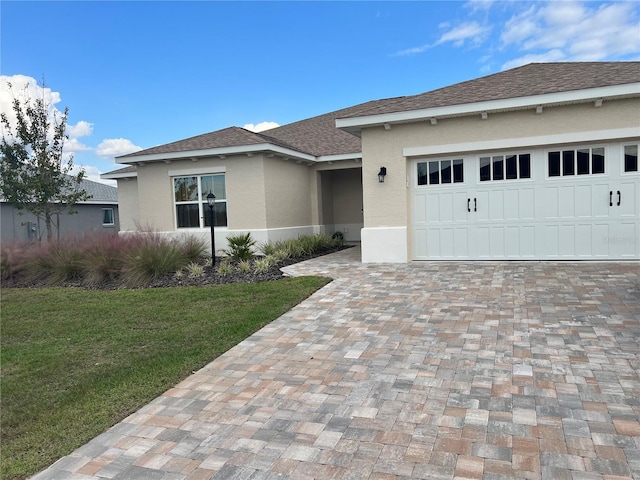 view of front of property featuring a garage and a front lawn