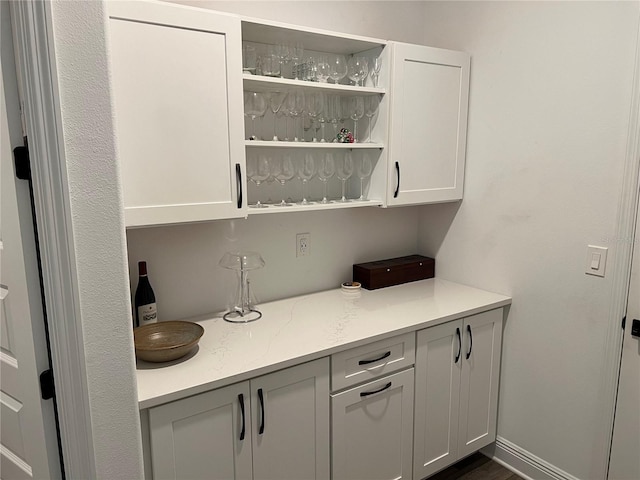 bar featuring white cabinets and dark wood-type flooring