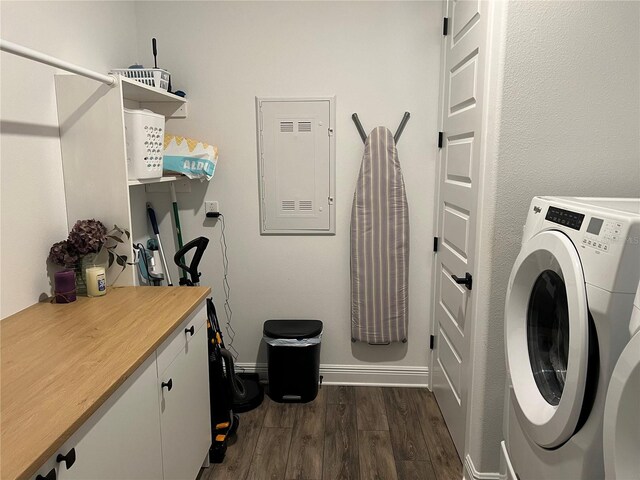 laundry room featuring dark wood-type flooring, electric panel, and washer / clothes dryer