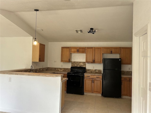 kitchen with kitchen peninsula, vaulted ceiling, hanging light fixtures, and black appliances