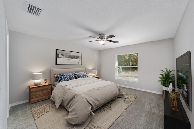 bedroom featuring a textured ceiling, ceiling fan, and dark carpet