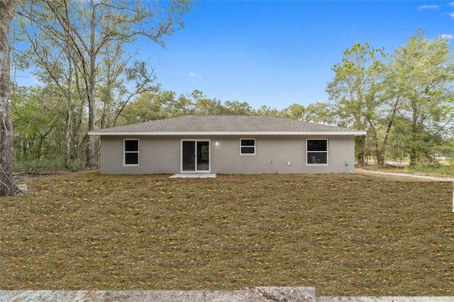 rear view of property with a lawn