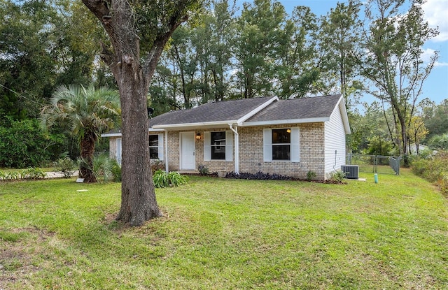 ranch-style house featuring central AC unit and a front lawn