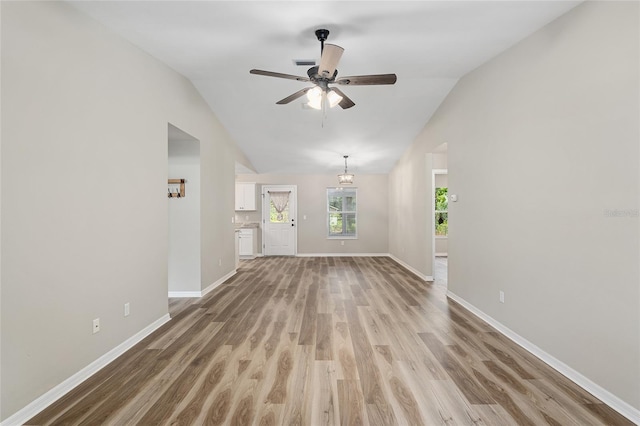 unfurnished living room featuring ceiling fan, wood-type flooring, and vaulted ceiling