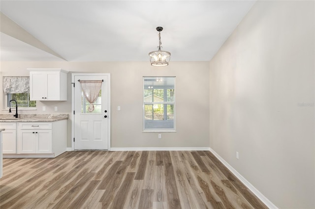 interior space featuring a chandelier, sink, a healthy amount of sunlight, and light hardwood / wood-style floors