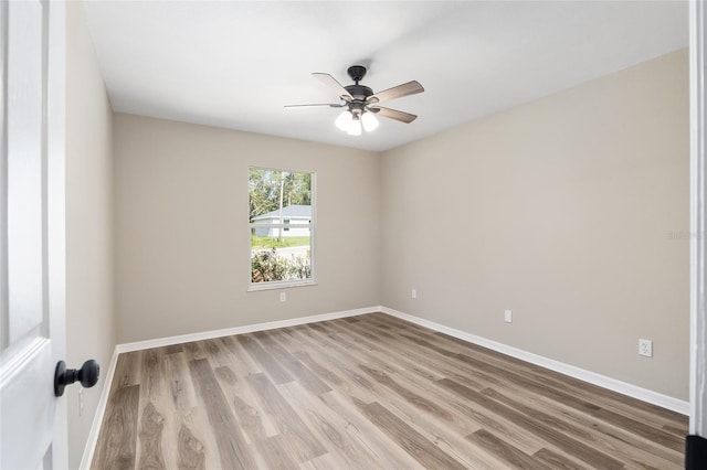 spare room with ceiling fan and light wood-type flooring