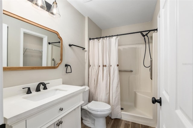 bathroom featuring vanity, toilet, hardwood / wood-style flooring, and curtained shower