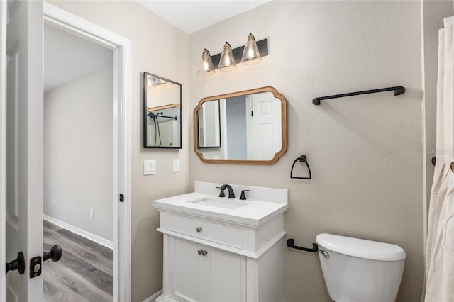 bathroom featuring toilet, vanity, and hardwood / wood-style flooring