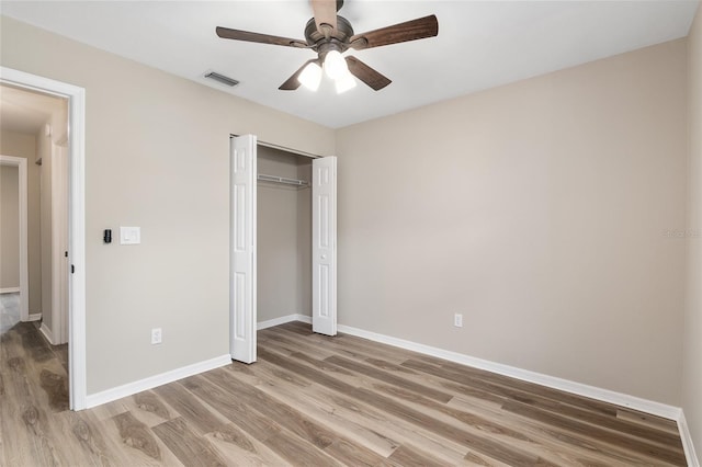 unfurnished bedroom with hardwood / wood-style floors, a closet, and ceiling fan