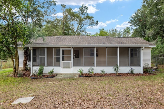 view of front of property featuring a sunroom and a front yard