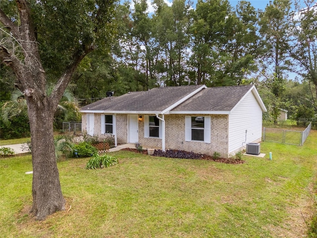 ranch-style home featuring a front lawn and central AC unit