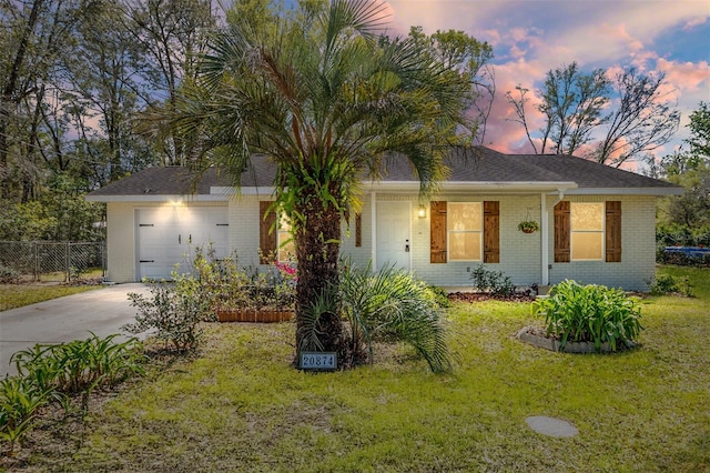 ranch-style home featuring concrete driveway, a garage, brick siding, and a yard