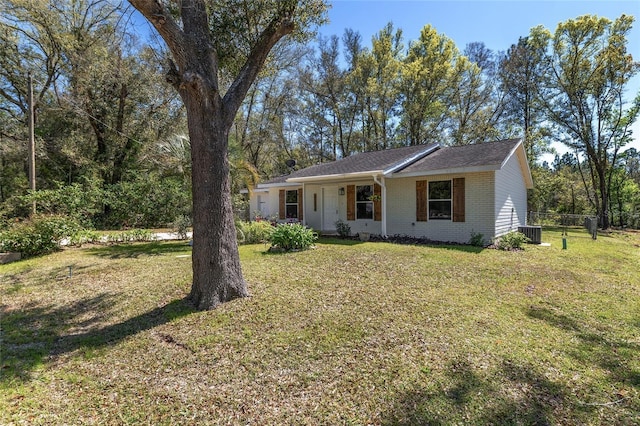 view of front of property featuring a front yard, central air condition unit, fence, and brick siding