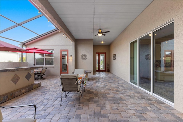 view of patio featuring ceiling fan and a lanai