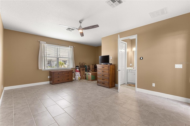 bedroom featuring ceiling fan, a textured ceiling, light tile patterned floors, and connected bathroom