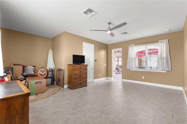 bedroom with ceiling fan, a textured ceiling, and light tile patterned floors