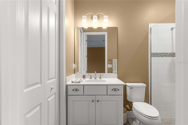 bathroom with tiled shower, toilet, and vanity