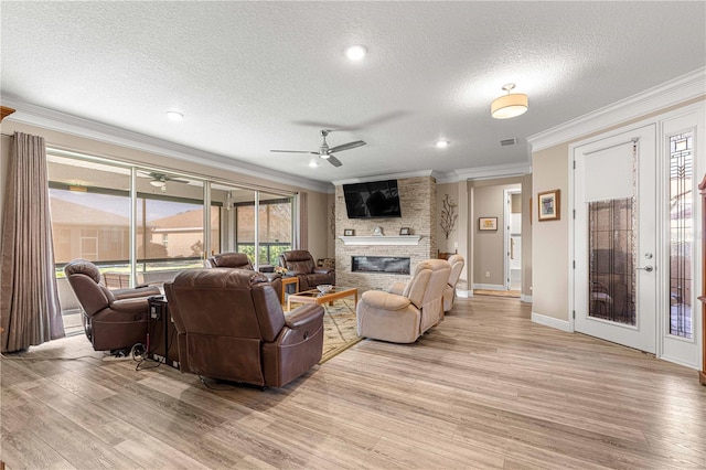 living room with ceiling fan, a textured ceiling, and light hardwood / wood-style flooring