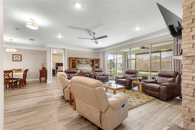 living room with ceiling fan, a textured ceiling, light wood-type flooring, and crown molding