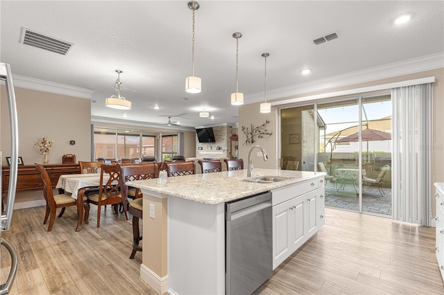 kitchen with white cabinetry, pendant lighting, sink, dishwasher, and a kitchen island with sink