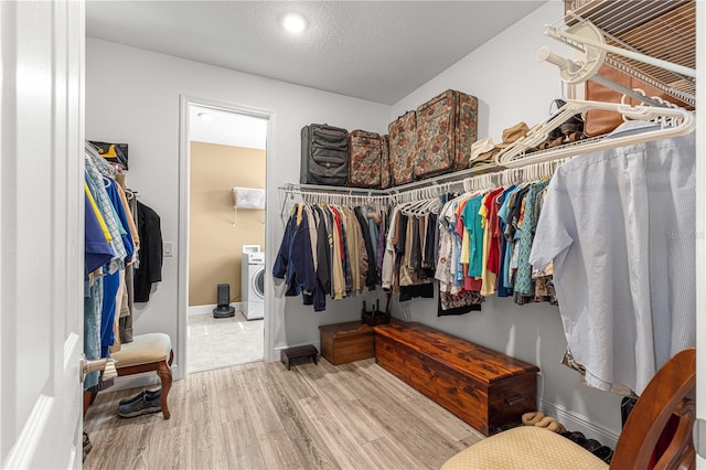 spacious closet with hardwood / wood-style flooring and washer / dryer