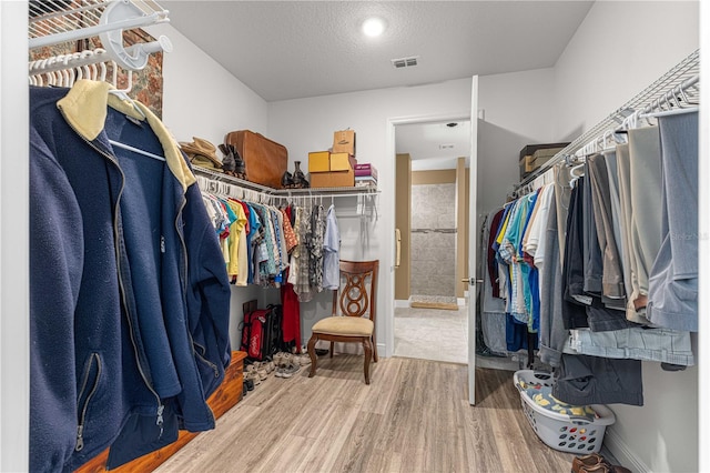 walk in closet with hardwood / wood-style floors