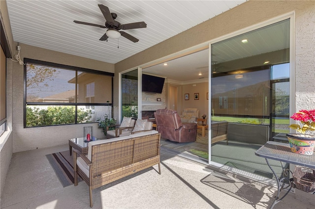 sunroom / solarium featuring ceiling fan