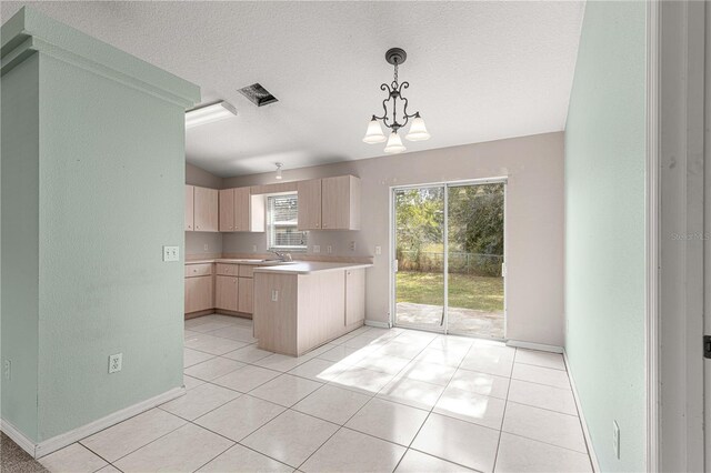 kitchen with sink, light brown cabinetry, a textured ceiling, light tile patterned floors, and a chandelier