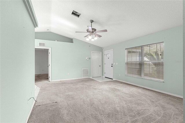 unfurnished living room with lofted ceiling, a textured ceiling, light colored carpet, and ceiling fan