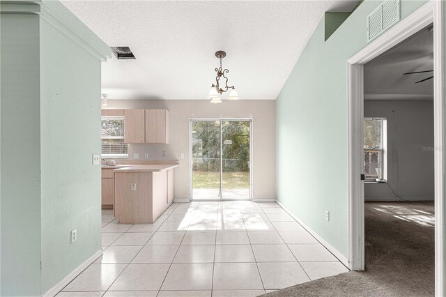 kitchen with light brown cabinetry, ceiling fan with notable chandelier, a textured ceiling, and light tile patterned floors