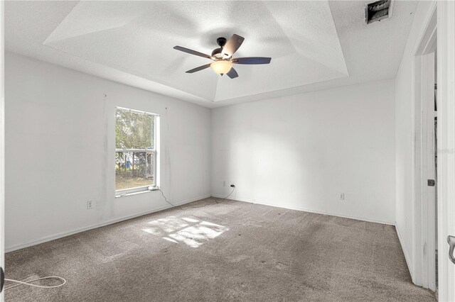 spare room featuring ceiling fan, a textured ceiling, a raised ceiling, and carpet floors