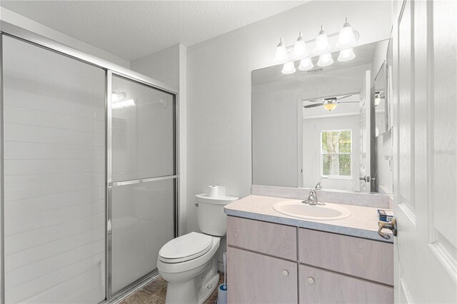 bathroom featuring ceiling fan, a textured ceiling, toilet, and a shower with door