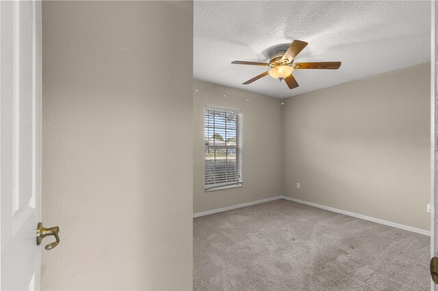 carpeted empty room with a textured ceiling and ceiling fan