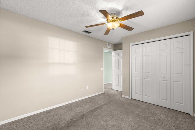 unfurnished bedroom with carpet flooring, a textured ceiling, ceiling fan, and a closet