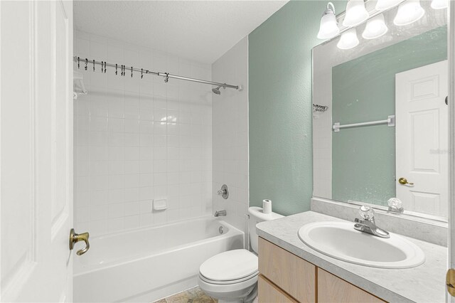 full bathroom featuring vanity, tiled shower / bath, toilet, and a textured ceiling