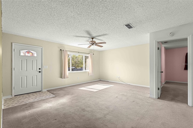 carpeted foyer with ceiling fan and a textured ceiling