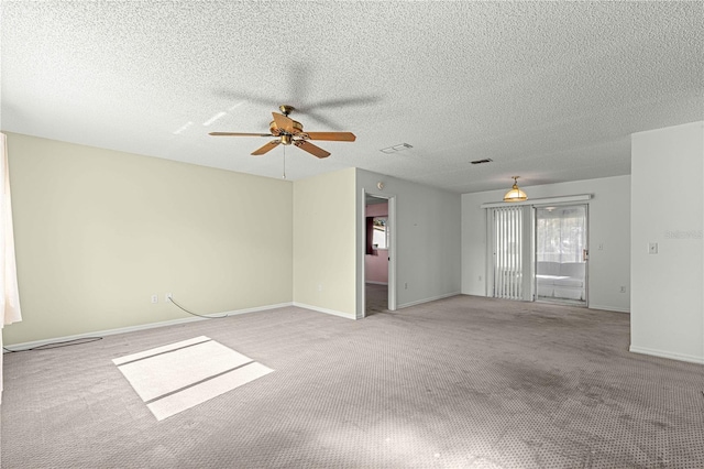 carpeted spare room with a textured ceiling and ceiling fan