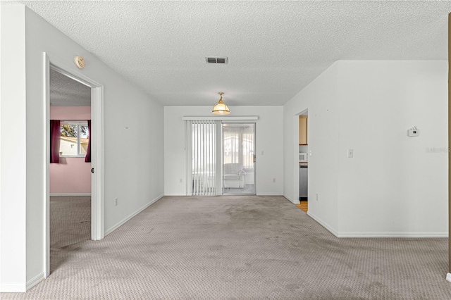 carpeted spare room featuring a textured ceiling