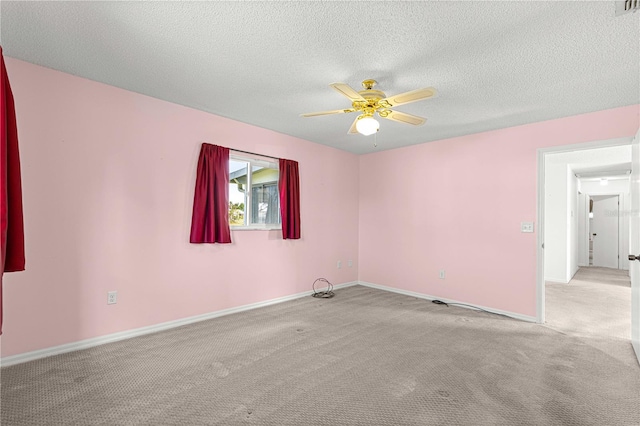 carpeted spare room featuring ceiling fan and a textured ceiling