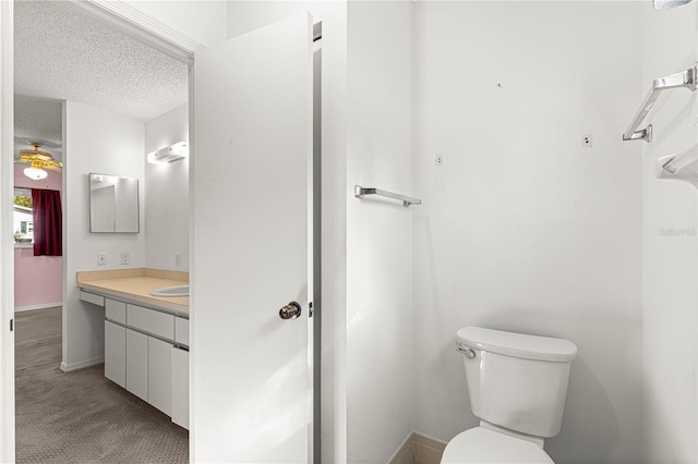 bathroom with toilet, vanity, and a textured ceiling